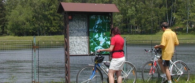 Cyclist in front of an information board
